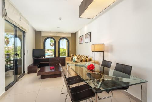 a dining room and living room with a glass table at AP Adriana Beach Resort in Albufeira