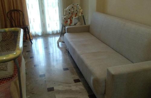 a couch sitting in a living room next to a window at Katerina's house in Kalopigado