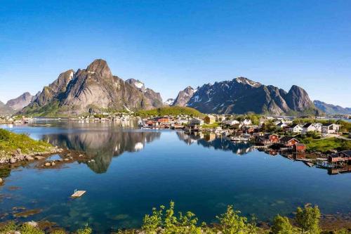 a small town on the water with mountains in the background at Reine Front View - Mountain & Seaview in Reine