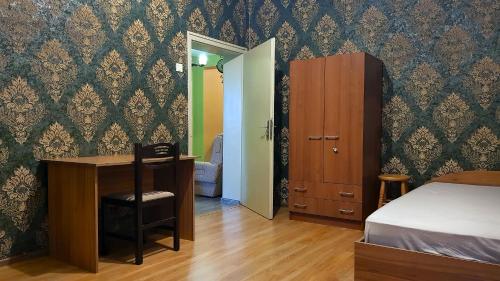 a bedroom with a bed and a desk and a bedroom with green walls at Дионея in Belogradchik