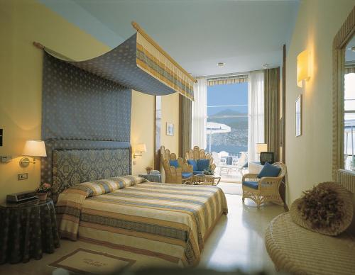 a hotel room with a bed and a large window at Beach Hotel Du Lac Malcesine in Malcesine