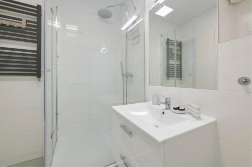 ソポトにあるDom & House - Apartments Sobieskiego Sopotの白いバスルーム(シンク、シャワー付)