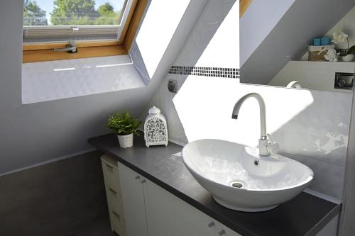 a bathroom with a white sink and a window at Apartament Słoneczny in Mrągowo