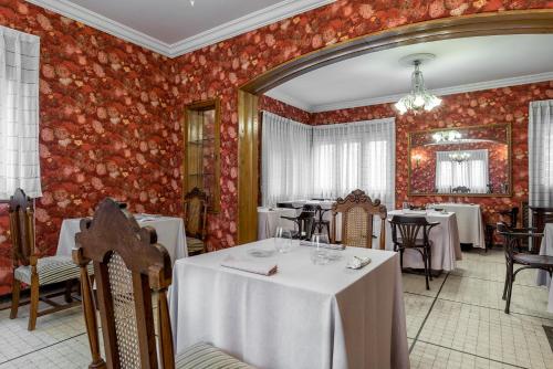 um restaurante com mesas e cadeiras e paredes vermelhas em Hotel Hontoria em Hontoria