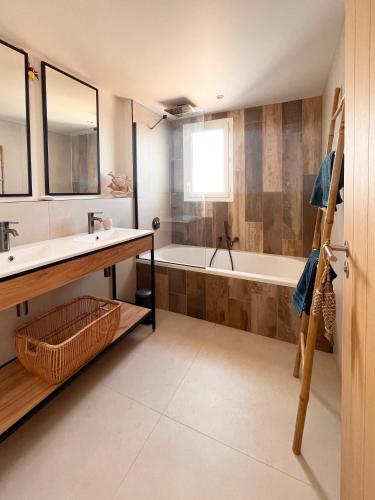 une salle de bain avec un lavabo et une baignoire dans l'établissement Villa Les Pins étoilés - 100m de la plage à La Couarde sur Mer, à La Couarde-sur-Mer