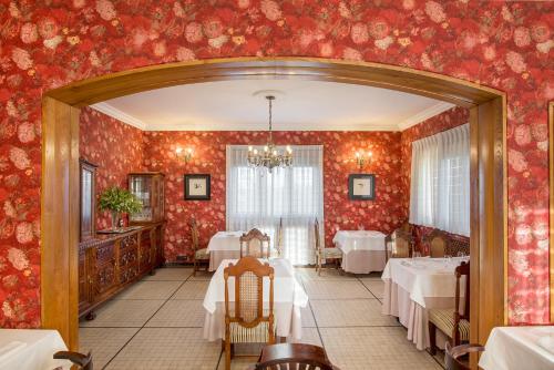 jadalnia ze stołami i czerwoną tapetą w obiekcie Hotel Hontoria w mieście Hontoria