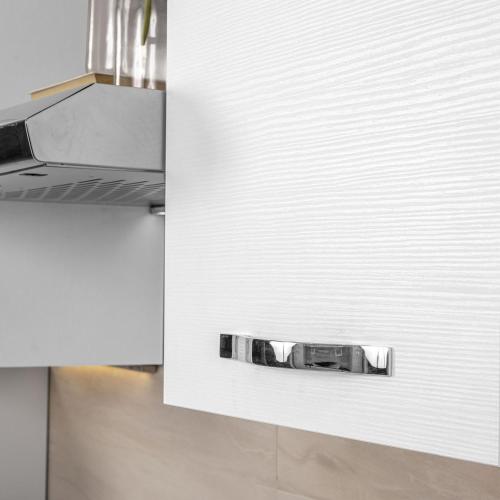 a kitchen with a white wall and a stove at La Mandronia Loft in Alghero