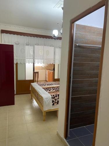 um quarto com uma cama, uma janela e uma escada em Maria Guest House em Përmet