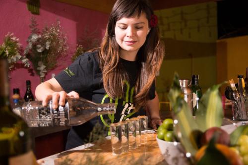 a woman pours a drink into glasses at Cactus Hostel & Suites in Guanajuato