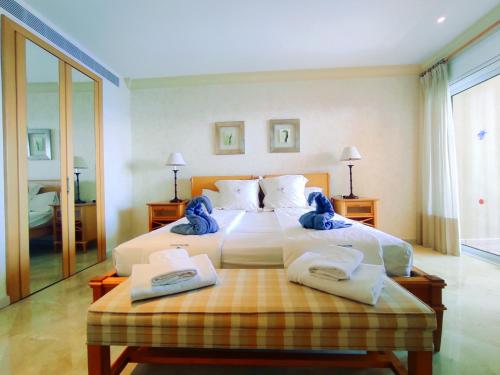 a bedroom with a large bed with towels on it at El Nautico Suites, Golf del Sur in San Miguel de Abona