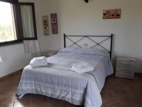 1 dormitorio con 1 cama con 2 toallas en Monolocale con giardino, en Castiglione della Pescaia