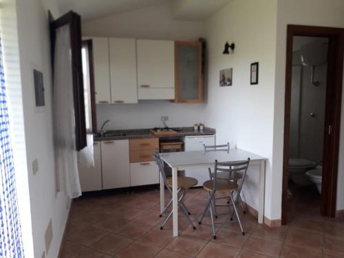 a kitchen with a table and chairs in a room at Monolocale con giardino in Castiglione della Pescaia