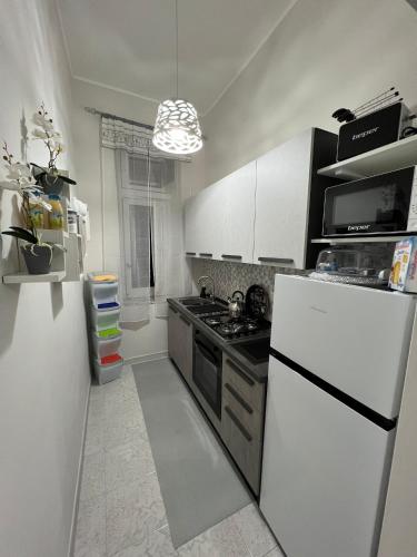 a kitchen with a white refrigerator and a stove at CASADOMA Oplonti Pompei in Torre Annunziata