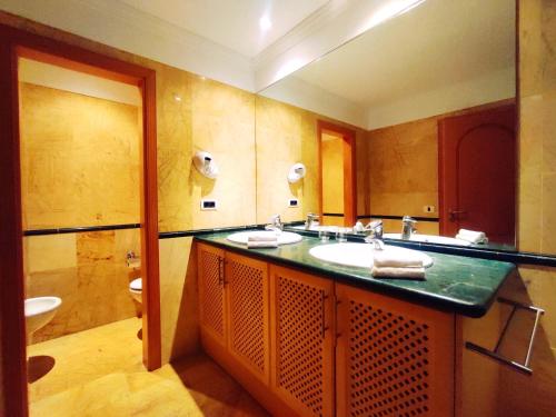 a bathroom with a sink and a mirror at El Nautico Suites, Golf del Sur in San Miguel de Abona