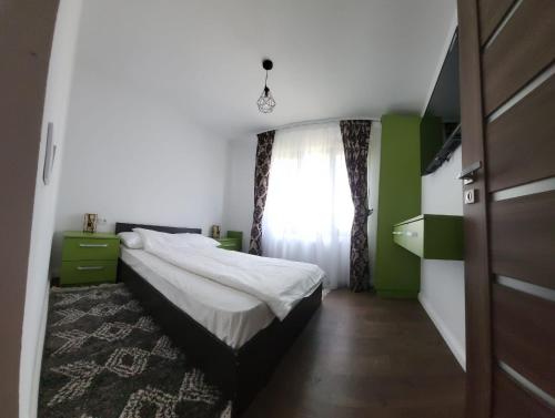 Habitación pequeña con cama y ventana en Racosim Residentials, en Seleuş