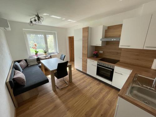 a kitchen and living room with a couch and a table at Erlebnisbauernhof Pension Waschnig in Sankt Kanzian