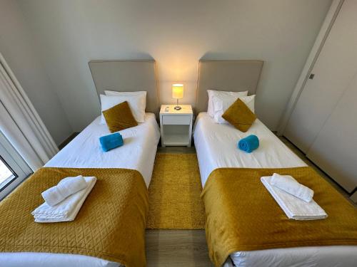 two beds in a small room with blue towels at Casa Bela Vista in Venda do Atalhinho