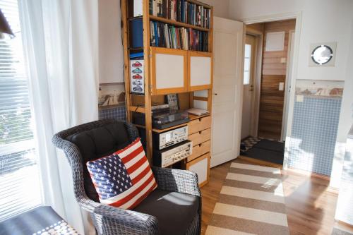 a living room with a chair with an american flag pillow at Erillinen ilmastoitu vierassviitti, Kokkola in Kokkola