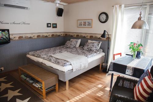 a bedroom with a bed and a clock on the wall at Erillinen ilmastoitu vierassviitti, Kokkola in Kokkola