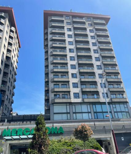 a tall apartment building with a sign on it at VistasAragon in Vigo
