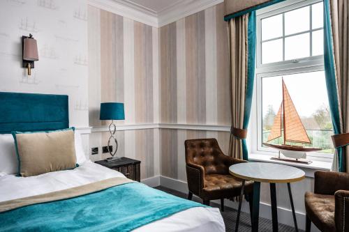 a bedroom with a bed and a sailboat on the window at Toravaig House Hotel in Teangue