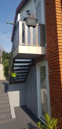a building with a balcony with a plant in a planter at Borostyán nyaralóház in Fonyód