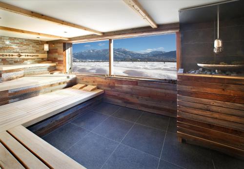 a sauna with a window and a view of the snow at Hotel Das Rübezahl in Schwangau