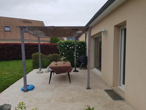 d'une terrasse avec une table et une pergola. dans l'établissement Chambres chez l'habitant, à Trangé