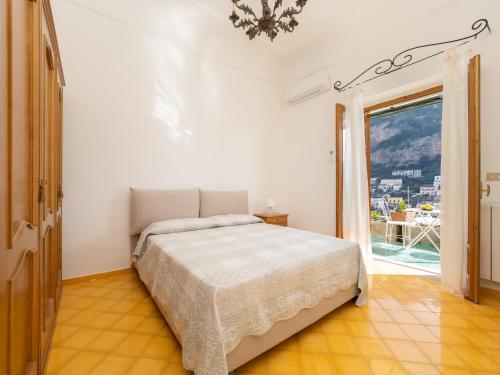 ein Schlafzimmer mit einem Bett und einem großen Fenster in der Unterkunft Rosa House - Breathtaking View of the Amalfi Coast in Positano