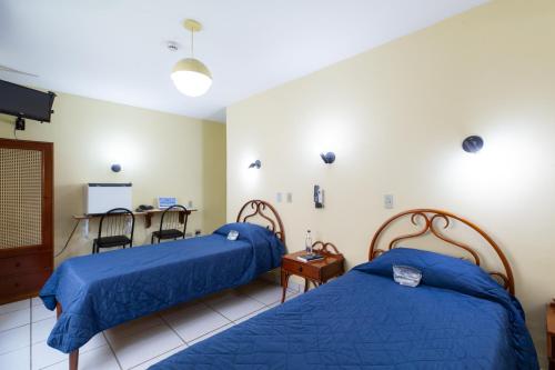 Habitación hospitalaria con 2 camas y mesa en Daher Center Hotel, en São Paulo