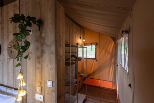 un pasillo de una casa con una habitación con paredes de madera en Glamping VALL de CODÓ en Terrades