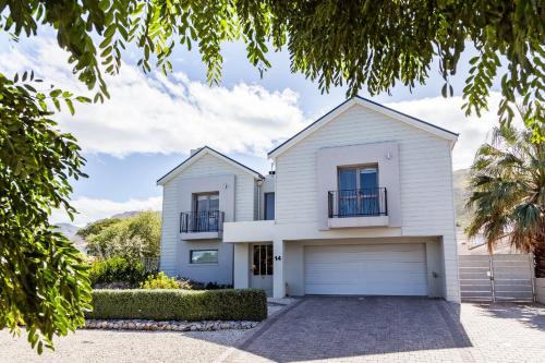 a white house with a garage at Nerf-af Cottage and private ROOMs at Onrus , Hermanus in Hermanus