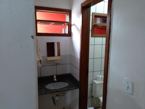 a bathroom with a sink and a window at Pousada Bromélias - Suítes e Aptos in Nova Viçosa