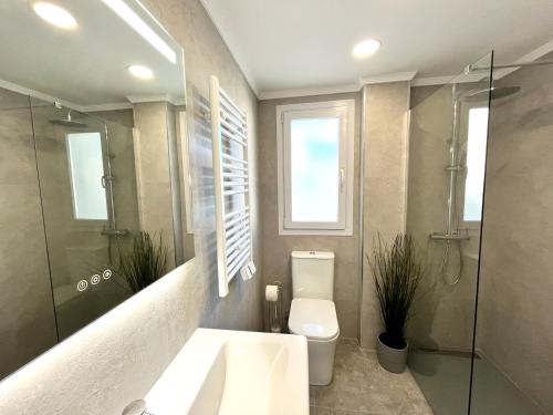 een badkamer met een toilet, een douche en een wastafel bij Penthouse mit private Dachterrasse und Blick auf das Meer, Berge ,Hafen in Estepona