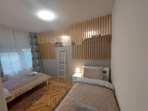 a small bedroom with two beds and a window at Ozzy Cozy in Zagreb