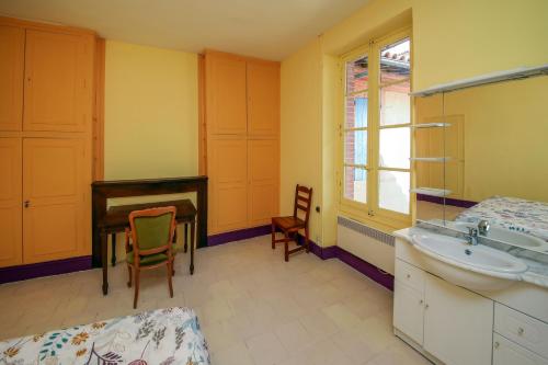 une salle de bain avec un lavabo, un bureau et un piano dans l'établissement Babanel, à Montans