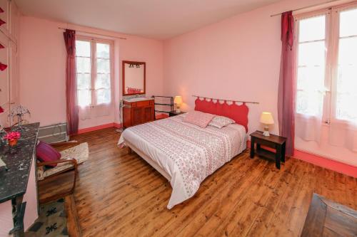 um quarto com uma cama e pisos e janelas em madeira em Babanel em Montans
