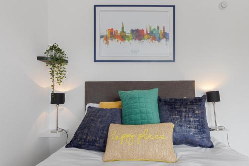 1 dormitorio con 1 cama con almohadas coloridas en Exeter City Centre Apartments Stoop Apartment en Exeter
