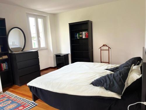 a bedroom with a large bed and a mirror at Casa Dilma in Lenno