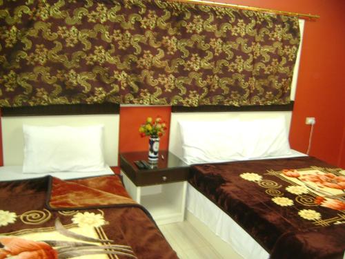 two beds in a hotel room with flowers on the wall at Isis Hostel 2 in Cairo