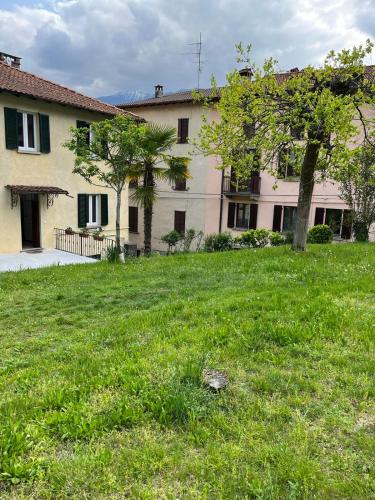 a large yard with a building and a tree at Casa Dilma in Lenno