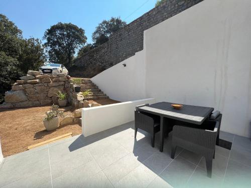 une table noire et des chaises sur une terrasse dans l'établissement Grand studio - Ajaccio - Salario - Capo di feno, à Ajaccio
