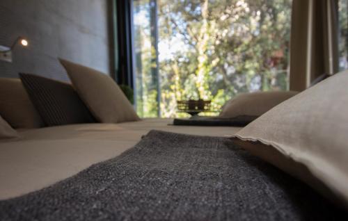 a bed with pillows in a room with a window at Boutique Hotel Valsabbion in Pula