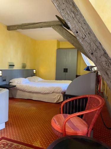 a bedroom with a bed and a chair in a room at Maison Kammerzell - Hotel & Restaurant in Strasbourg