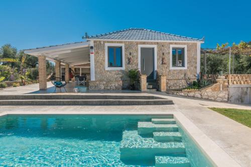 une maison avec une piscine en face d'une maison dans l'établissement Binios Villa, à Vasilikos