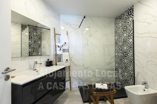 La salle de bains est pourvue d'un lavabo, d'un miroir et de toilettes. dans l'établissement Ribamar Bluevillas T1 by ACasaDasCasas - Apartment 3, à Ericeira