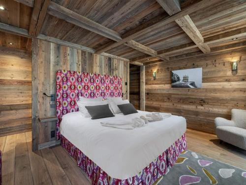 una camera con un grande letto e una sedia di Chalet Les Belleville, 8 pièces, 15 personnes - FR-1-570-25 a Saint-Martin-de-Belleville