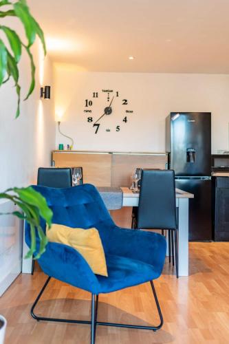 a living room with a blue couch and a clock on the wall at Sheffield City Centre Apartment & Balcony in Sheffield