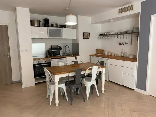 - une cuisine avec une table et des chaises en bois dans l'établissement Appartement très calme avec jardin plein sud, à Lyon