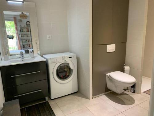 een badkamer met een wasmachine en een toilet bij Appartement très calme avec jardin plein sud in Lyon